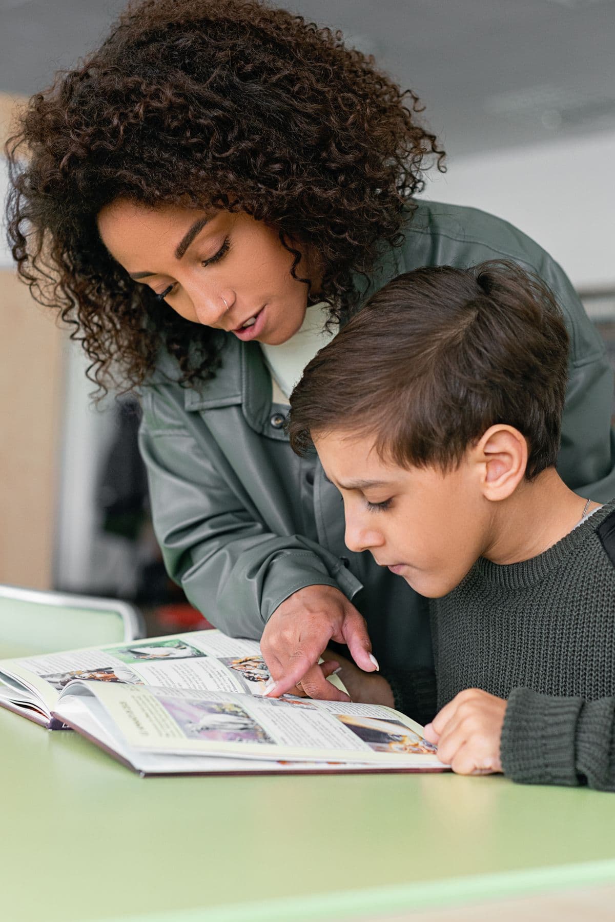 An ARISE instructor guiding a young reader one-on-one
